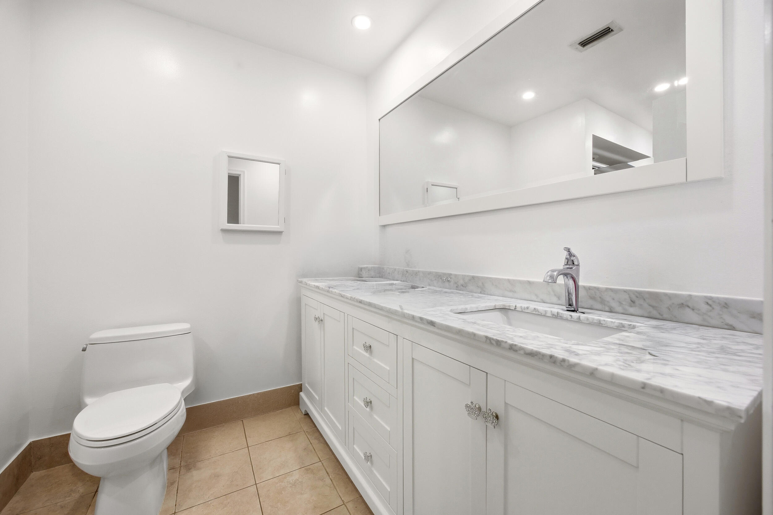 375 Northwest 53rd Street Boca Raton, FL 33487 - Photo 9 of 14 a bathroom with a granite countertop sink a toilet and a mirror