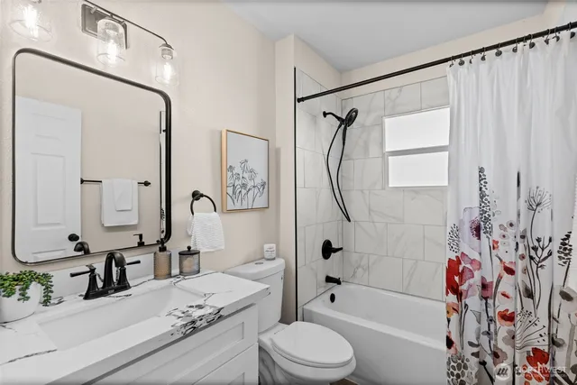 a bathroom with a granite countertop sink a toilet and shower