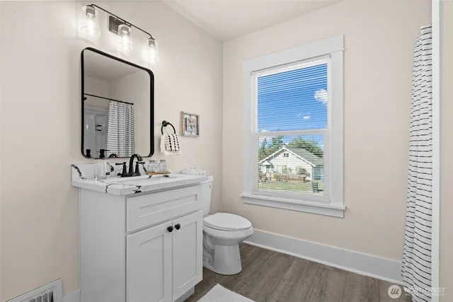 a bathroom with a toilet a sink a vanity and mirror