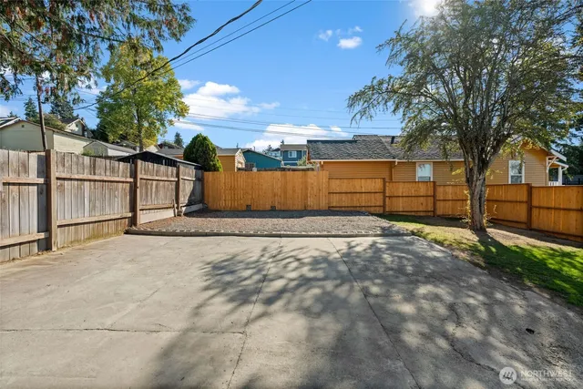 a view of backyard with wooden fence