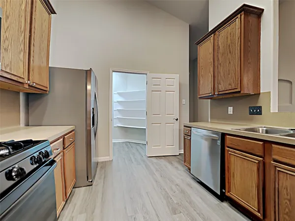 a kitchen with granite countertop wooden floors and stainless steel appliances