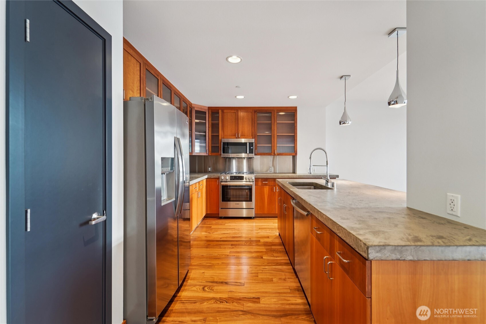 2716 Elliott Avenue, Unit 802 Seattle, WA 98121 - Photo 21 of 34 a large kitchen with kitchen island a sink stainless steel appliances and a counter top space