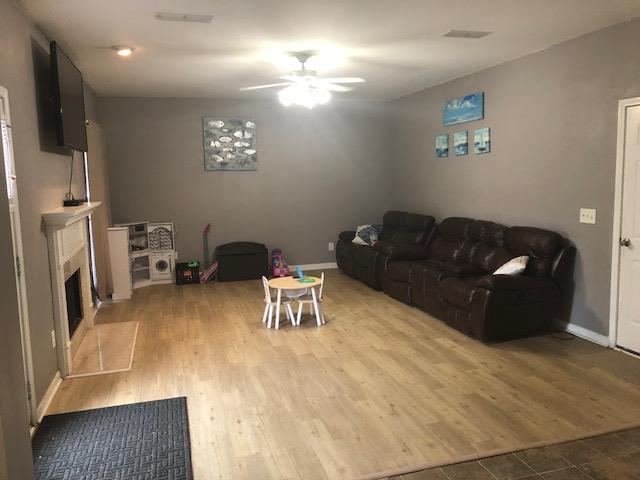 Large living room features new flooring and wood burning fireplace