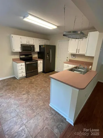 a kitchen with stainless steel appliances a stove a sink and a microwave