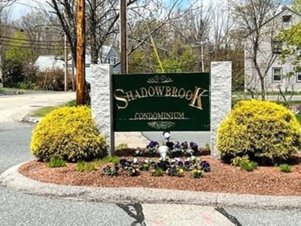 6 Shadowbrook Lane, Unit 59 Milford, MA 01757 - Photo 1 of 25 a sign on the side of the road