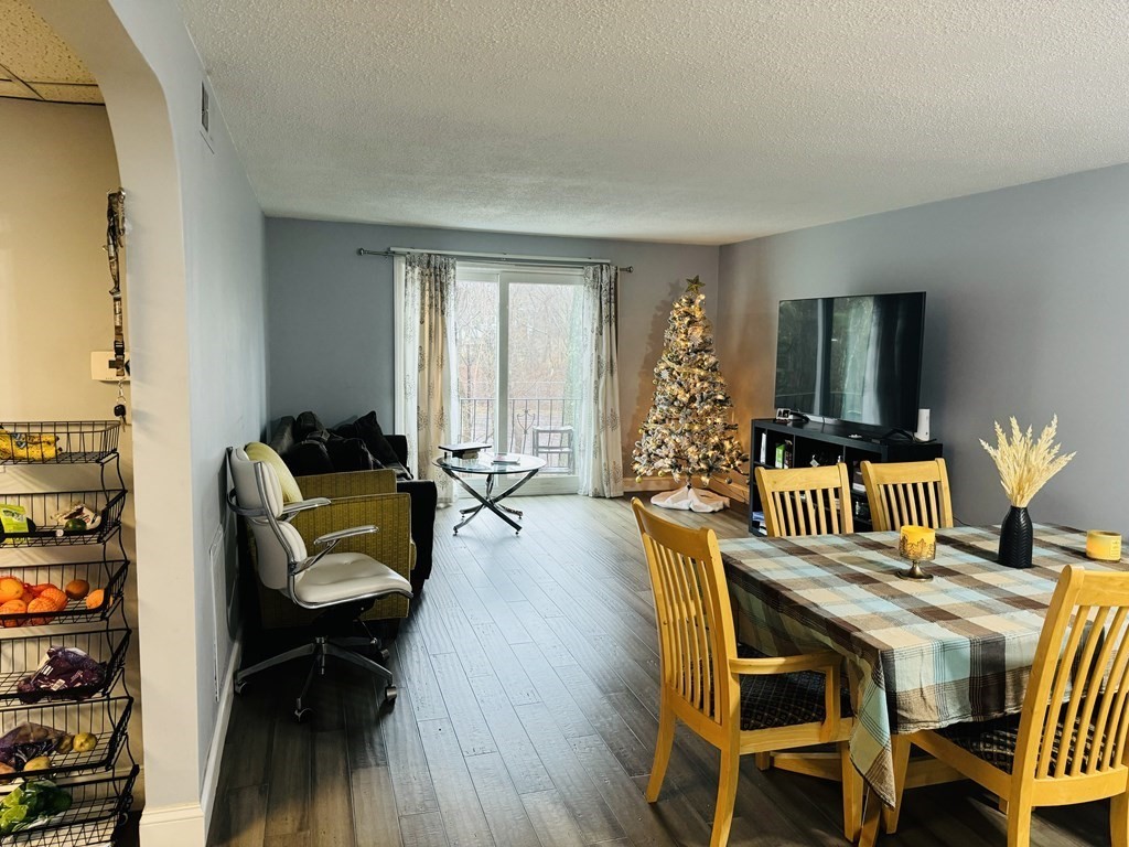 6 Shadowbrook Lane, Unit 59 Milford, MA 01757 - Photo 2 of 25 a living room with furniture and wooden floor