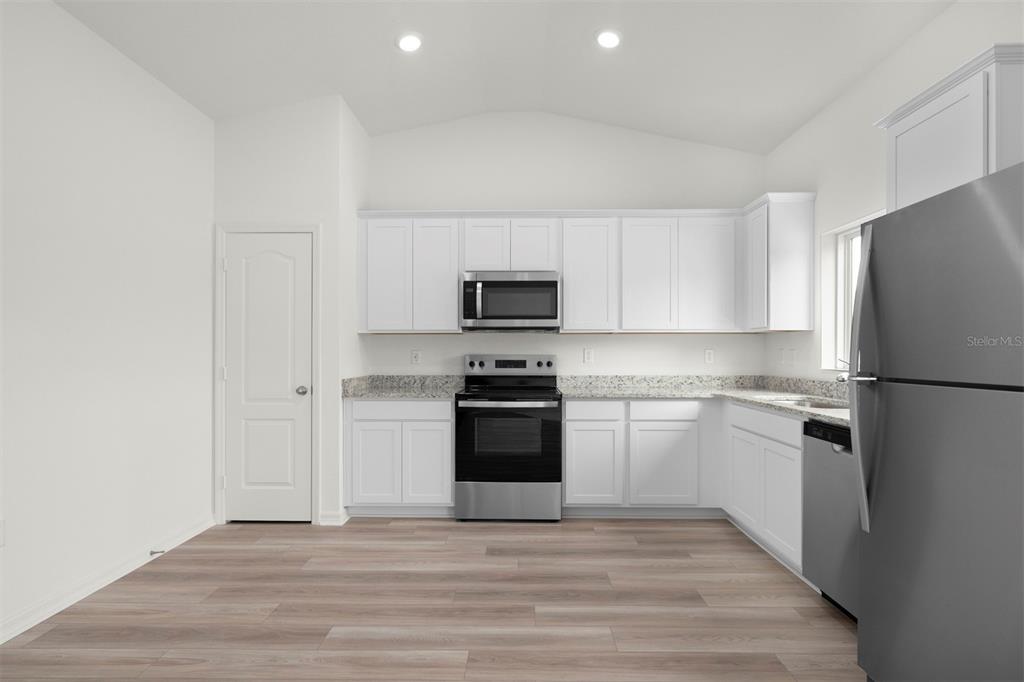 13300 Tula Loop Astatula, FL 34705 - Photo 3 of 18 a kitchen with a refrigerator stove and white cabinets