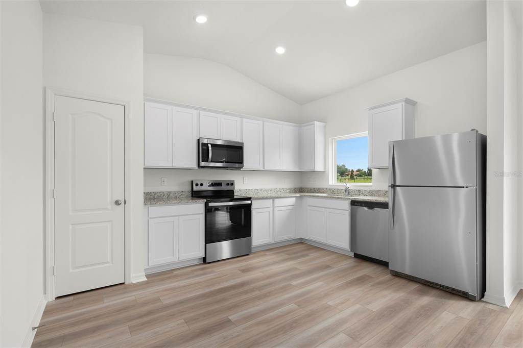 13300 Tula Loop Astatula, FL 34705 - Photo 4 of 18 a kitchen with a refrigerator stove and white cabinets