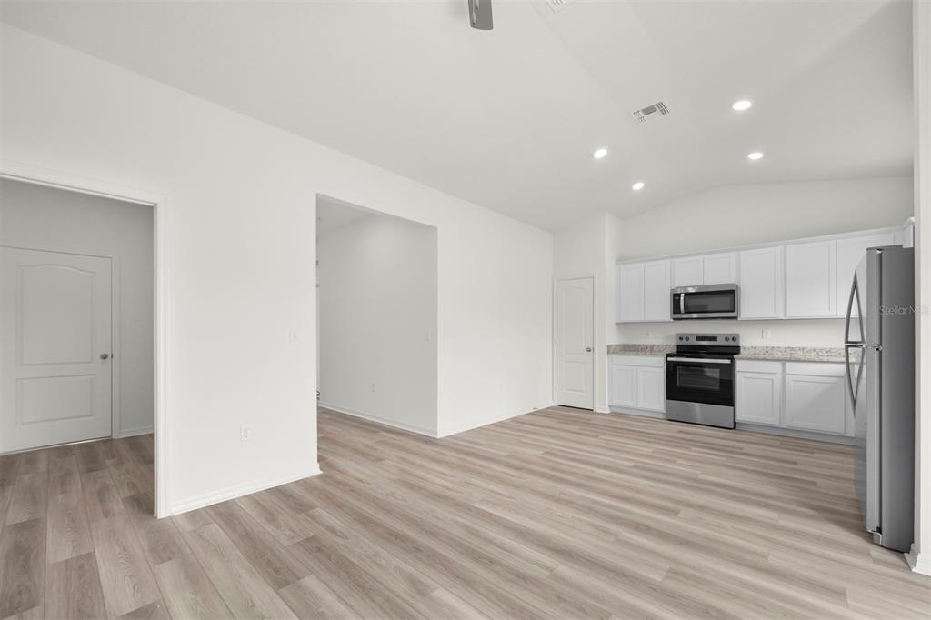 13300 Tula Loop Astatula, FL 34705 - Photo 5 of 18 a kitchen with granite countertop a refrigerator and a stove top oven