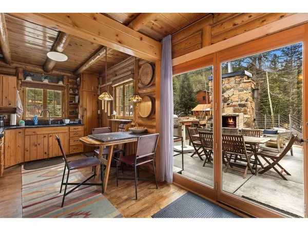 a dining room with wooden floor and large windows