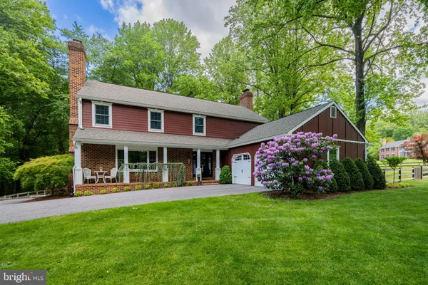 a front view of a house with porch and garden