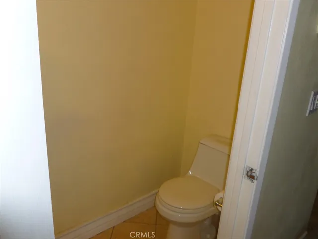 a white toilet sitting next to a small window