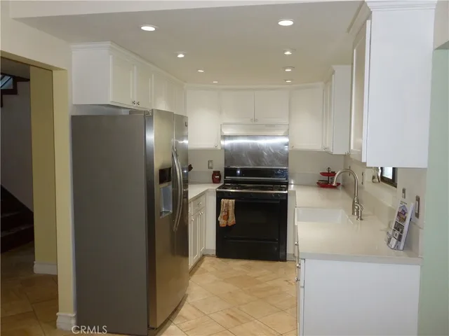 a kitchen with a refrigerator sink and stainless steel appliances