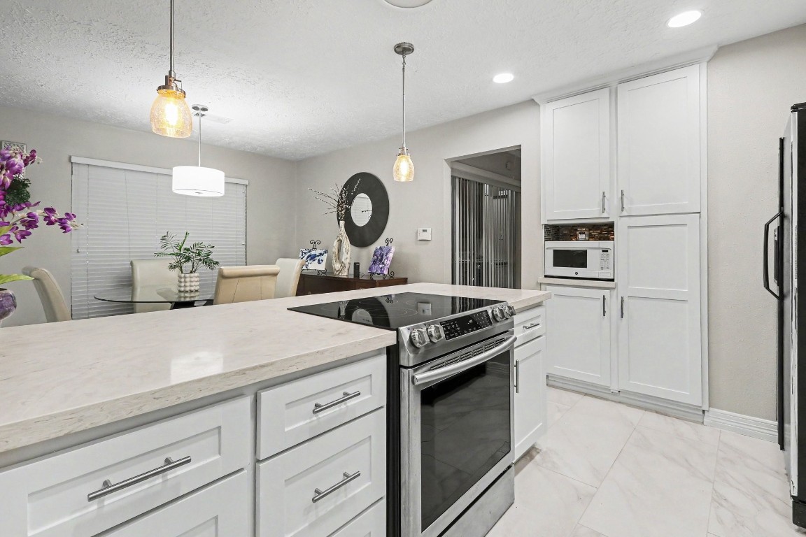 8327 Spring Wind Drive Houston, TX 77040 - Photo 11 of 30 New oven and cooktop and ample storage in this kitchen