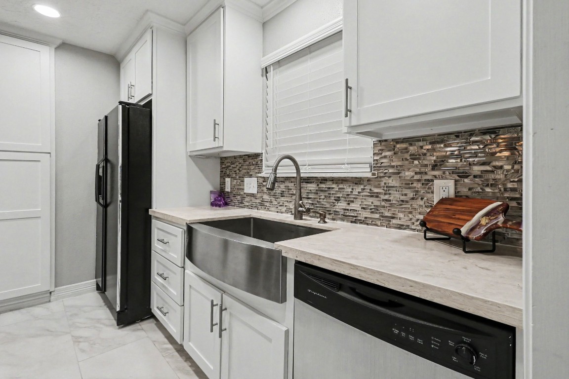 8327 Spring Wind Drive Houston, TX 77040 - Photo 12 of 30 Eye-catching backsplash and farmhouse sink complete this kitchen