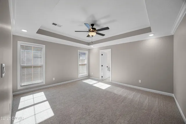 an empty room with windows and ceiling fan