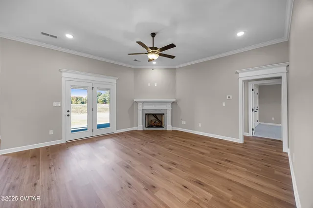 a view of an empty room with a fireplace and a window