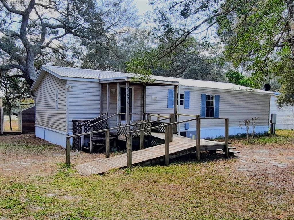 a view of a house with a backyard and a tree