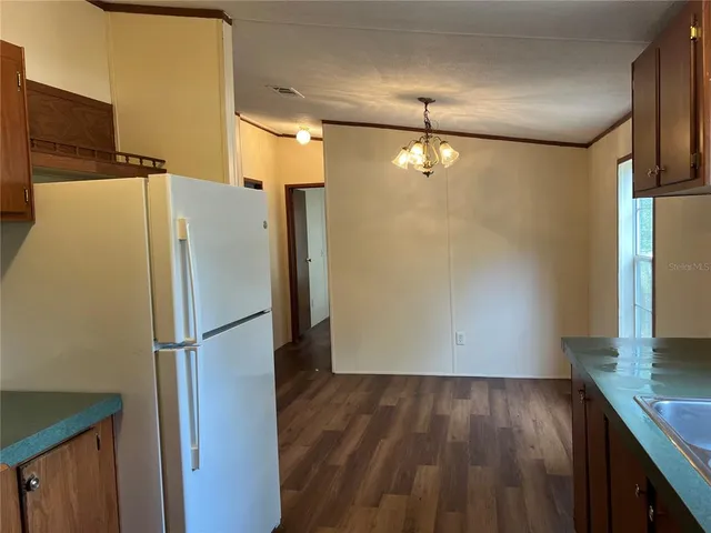 a room with wooden floor and a refrigerator