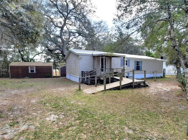 a view of a house with backyard and a tree