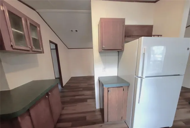 a white refrigerator freezer and a stove sitting inside of a kitchen