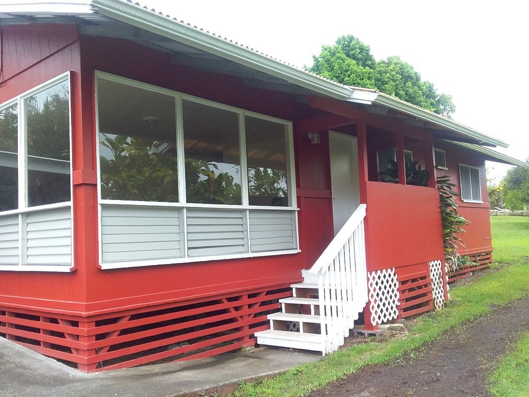 18-1656 Volcano Road Mountain View, HI 96771 - Photo 1 of 14 a yellow and red bench sitting in front of a house