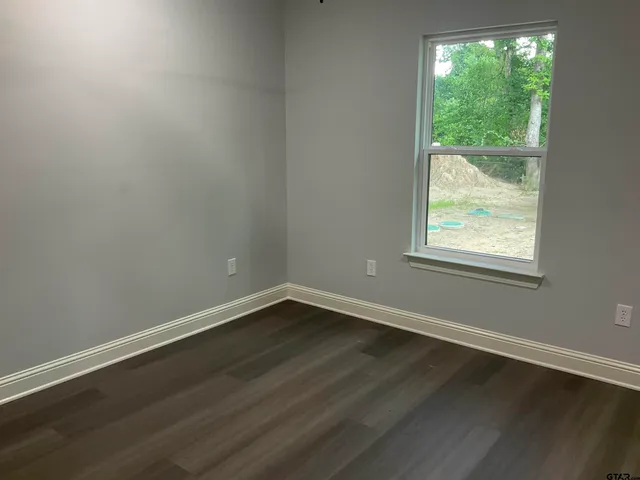 a view of a small space with wooden floor and windows