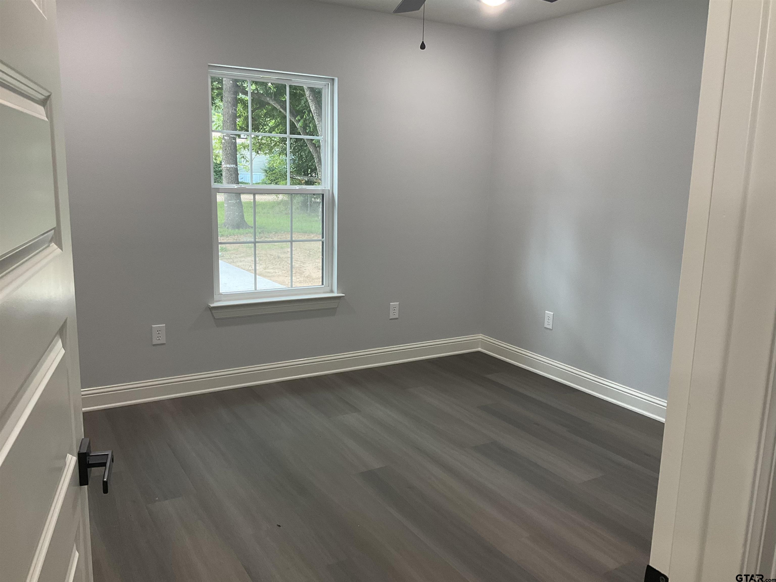 13220 Teton Road Tyler, TX 75709 - Photo 12 of 35 an empty room with wooden floor and windows