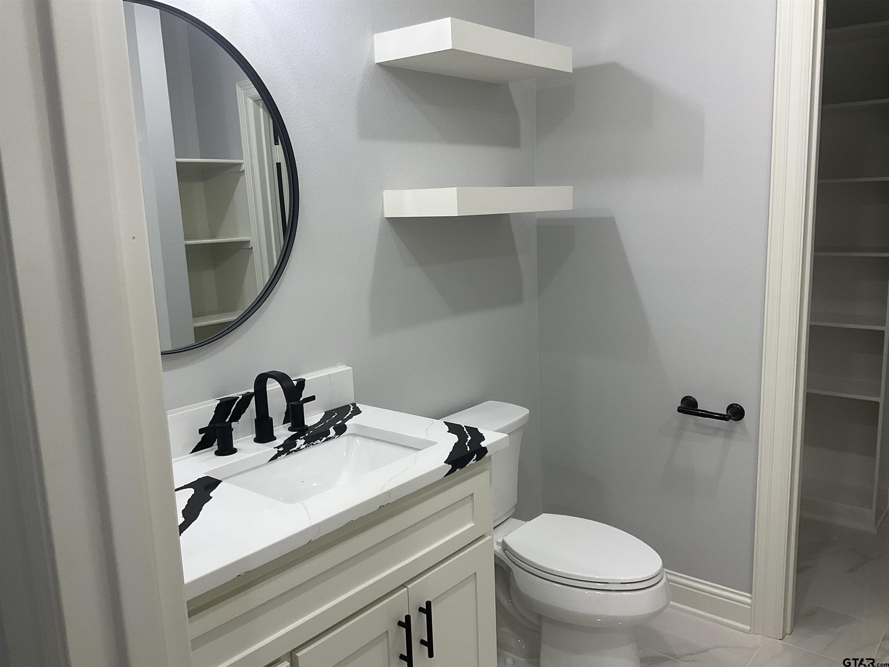 13220 Teton Road Tyler, TX 75709 - Photo 13 of 35 a bathroom with a sink toilet and mirror