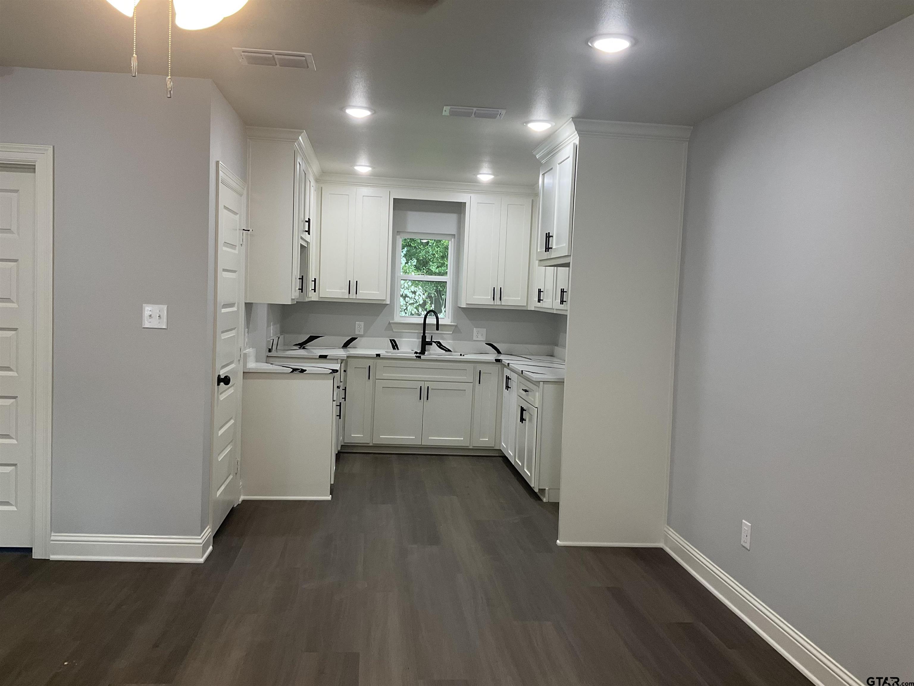 13220 Teton Road Tyler, TX 75709 - Photo 2 of 35 a kitchen with a sink cabinets stainless steel appliances and a window