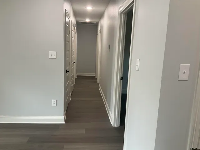a view of a hallway with wooden floor