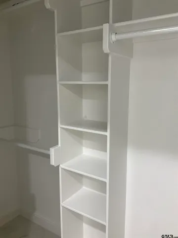 a view of walk in closet with empty racks