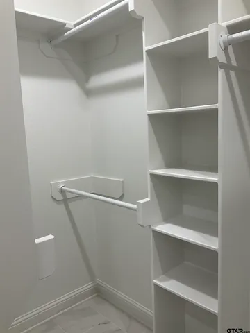 a view of walk in closet with empty racks