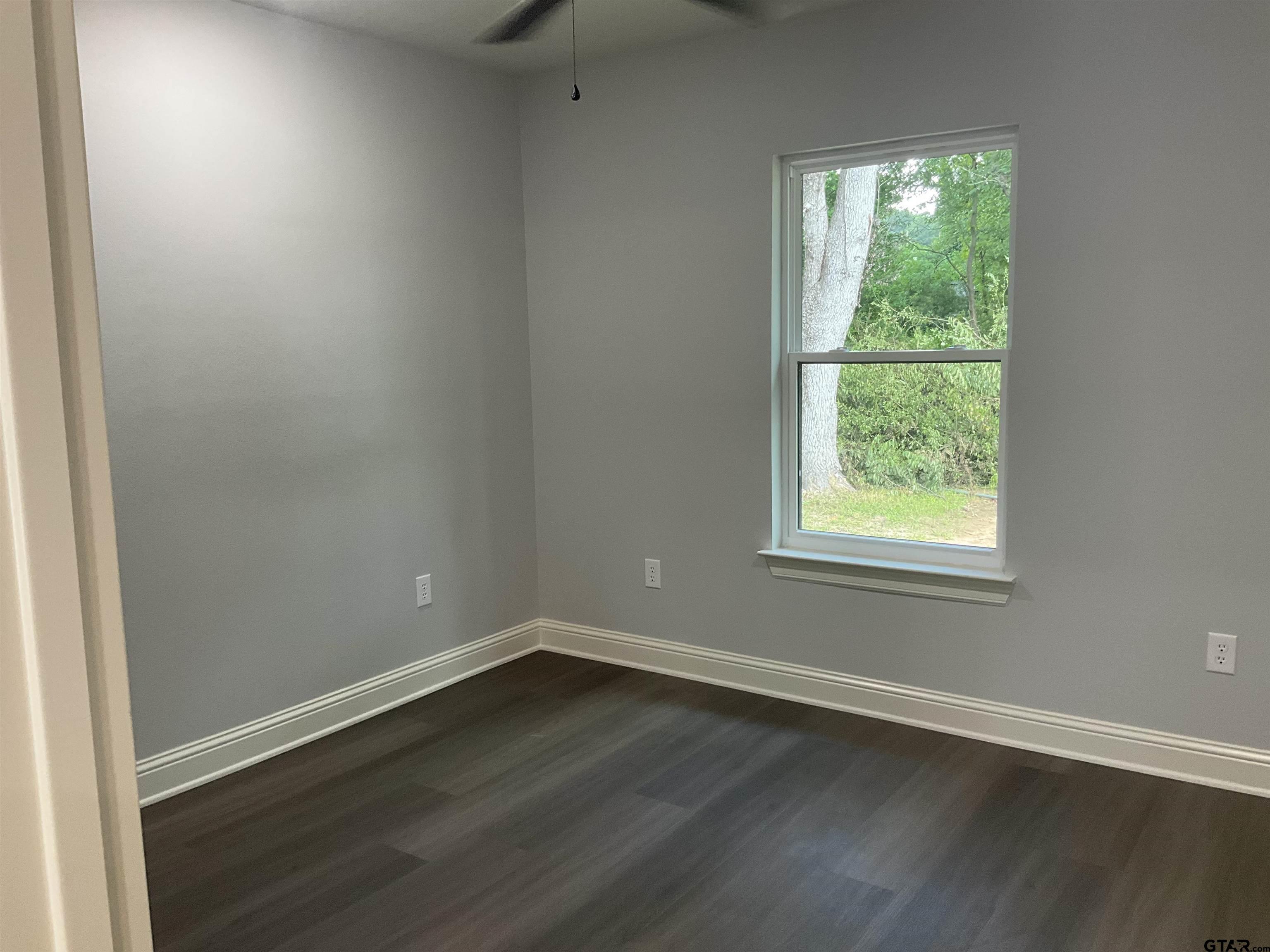 13220 Teton Road Tyler, TX 75709 - Photo 6 of 35 an empty room with wooden floor and windows