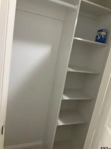 a view of walk in closet with empty racks