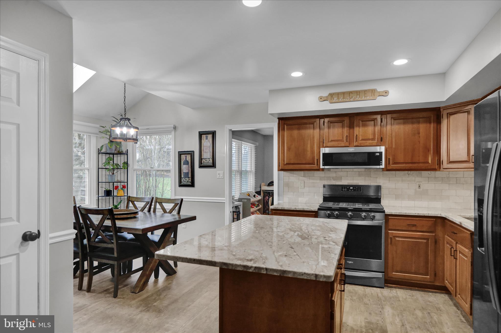 2930 Reedy Road Sinking Spring, PA 19608 - Photo 9 of 45 a kitchen with stainless steel appliances kitchen island granite countertop a table chairs stove and refrigerator