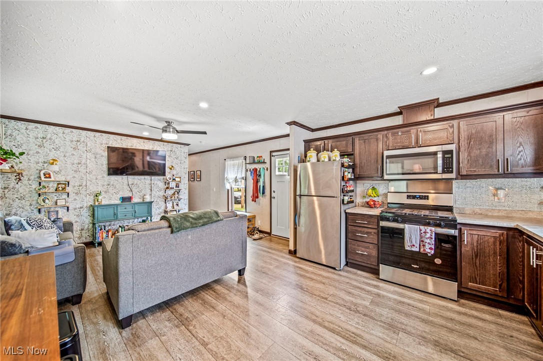 202 West Main Road, Unit LOT 13 Conneaut, OH 44030 - Photo 23 of 23 Kitchen featuring ornamental molding, appliances with stainless steel finishes, open floor plan, light wood-style flooring, and light countertops