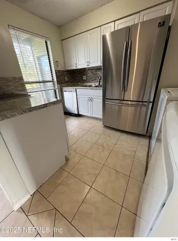 a kitchen with stainless steel appliances a refrigerator sink and cabinets