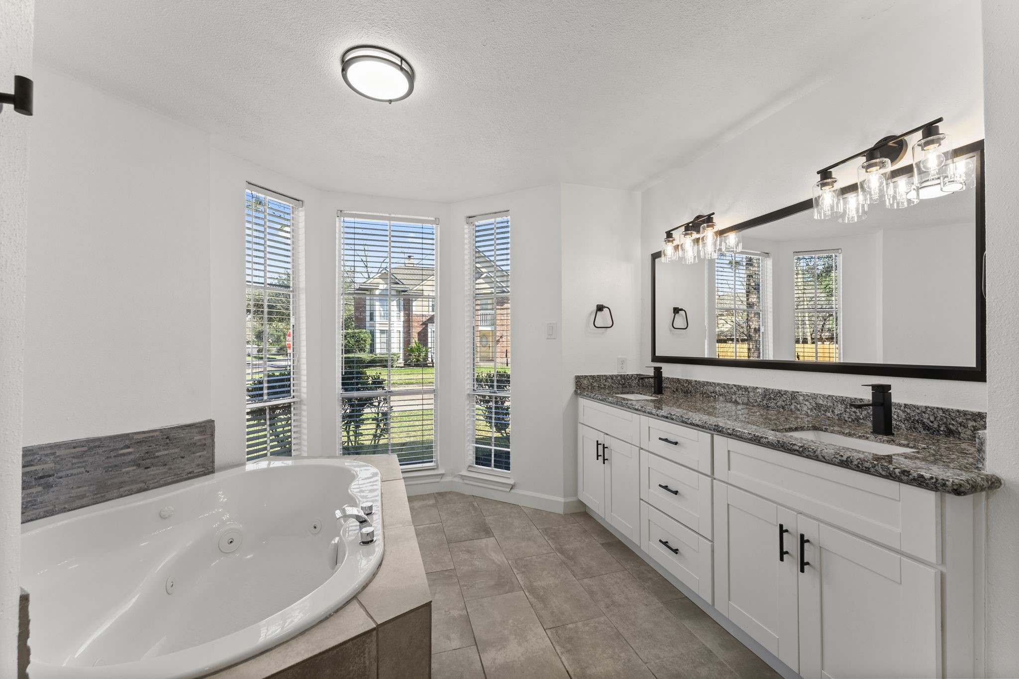1678 Beaconshire Houston, TX 77077 - Photo 12 of 30 a bathroom with a granite countertop tub sink and mirror