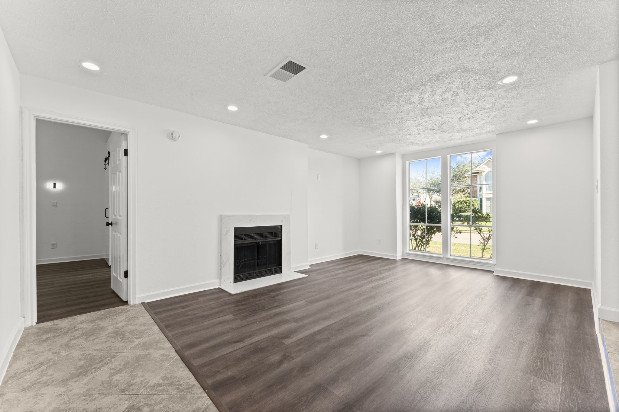 1678 Beaconshire Houston, TX 77077 - Photo 5 of 30 an empty room with wooden floor and a fireplace