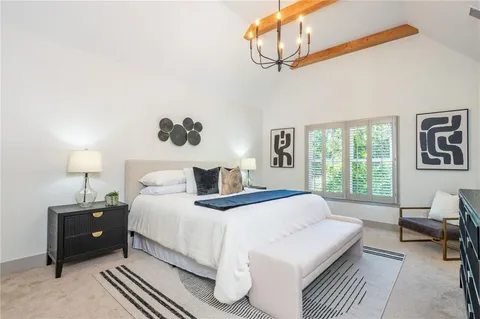 a bedroom with a bed a chandelier and a window