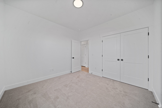 1117 East Shilow Road, Unit 106 Erda, UT 84074 - Photo 15 of 21 Spacious room featuring light-colored carpeting, white baseboards, and bright white walls