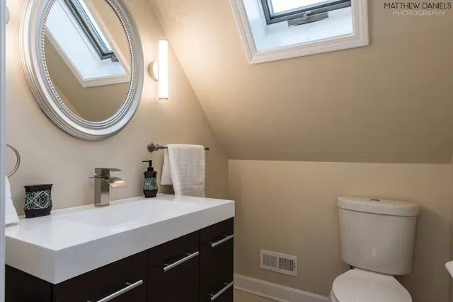 a bathroom with a toilet a sink and a mirror