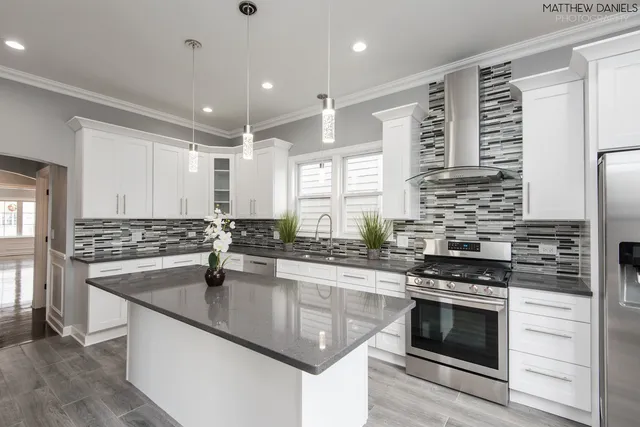 a kitchen with stainless steel appliances granite countertop a sink stove and cabinets
