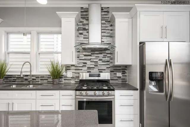 a kitchen with stainless steel appliances granite countertop a stove a refrigerator and a sink
