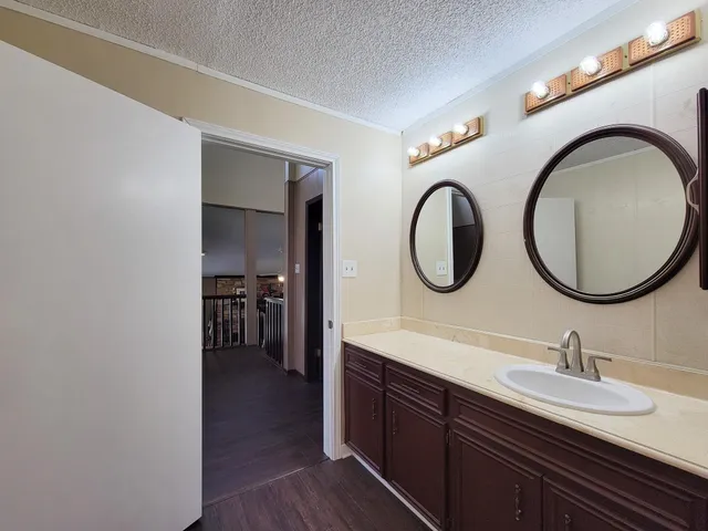 a bathroom with a granite countertop sink and a mirror