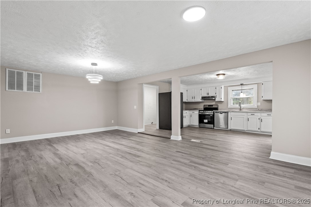 2302 Odom Road Hope Mills, NC 28348 - Photo 2 of 33 an empty room with wooden floor and windows