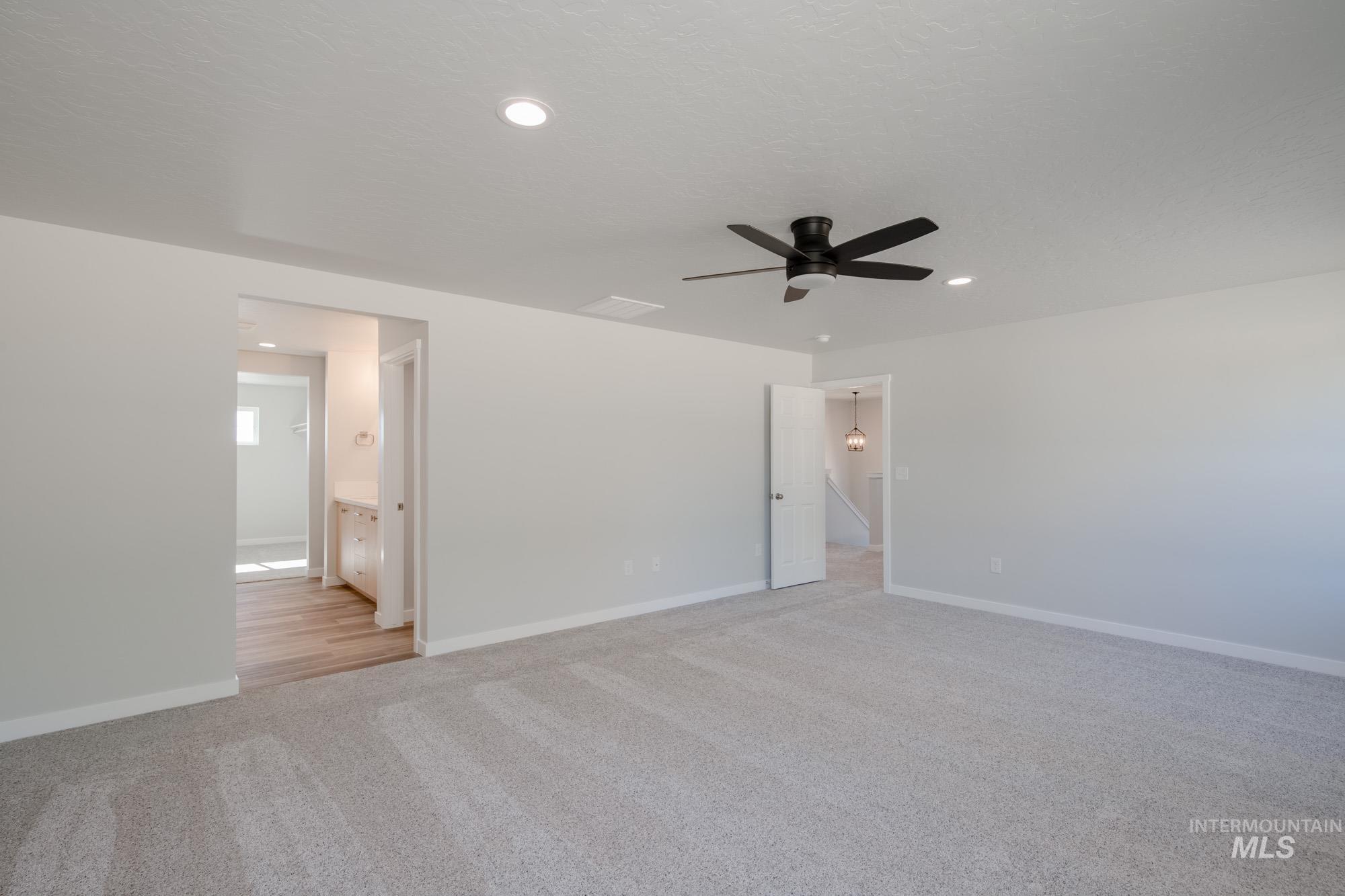 3230 South Maple Rnch Way Nampa, ID 83686 - Photo 19 of 27 Unfurnished bedroom featuring light colored carpet, recessed lighting, a ceiling fan, and connected bathroom