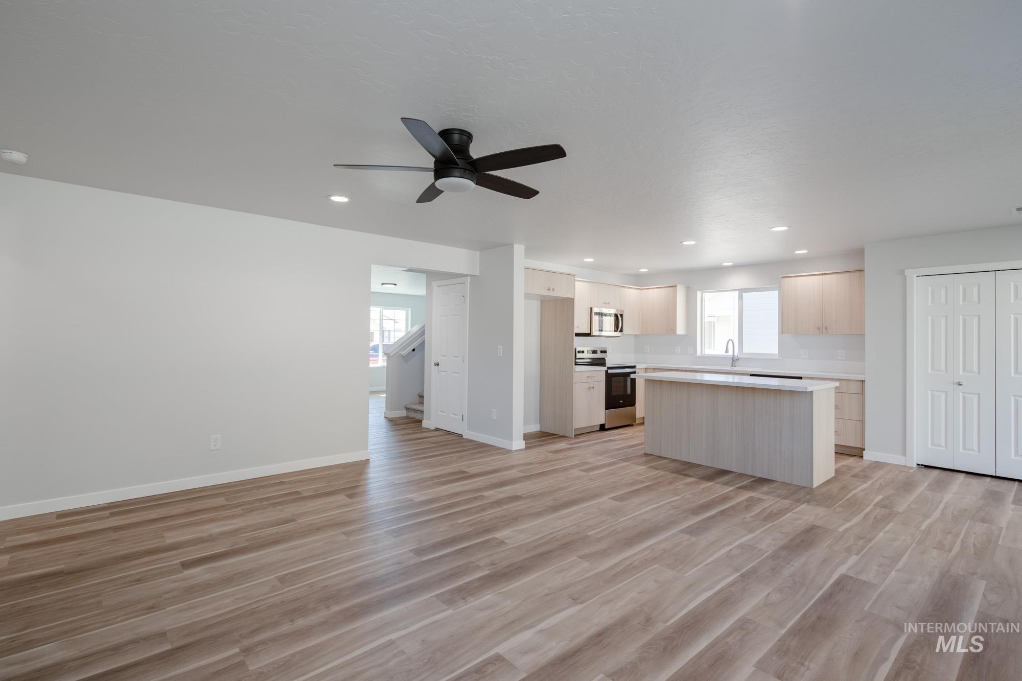 3230 South Maple Rnch Way Nampa, ID 83686 - Photo 27 of 27 Kitchen featuring a kitchen island, open floor plan, light countertops, appliances with stainless steel finishes, and light wood finished floors