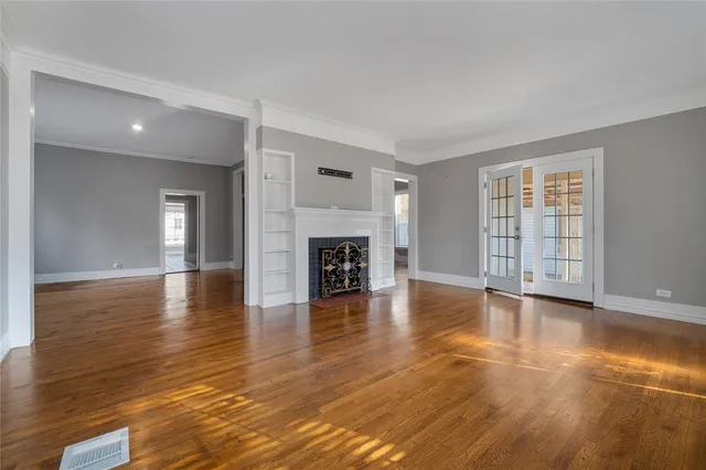 a view of a livingroom with wooden floor and a fireplace